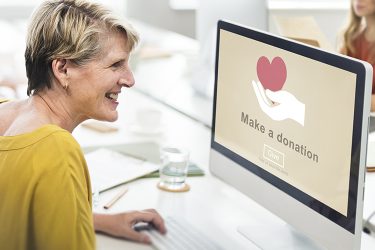 Women in yellow shirt making an online charity donation