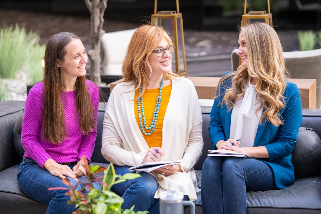 Three Paradigm Marketing and Design sales team members sitting and discussing sales enablement