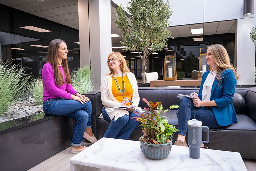 Founder of Paradigm Marketing and Design, Rachel Durkan, talking with two other Paradigm team members