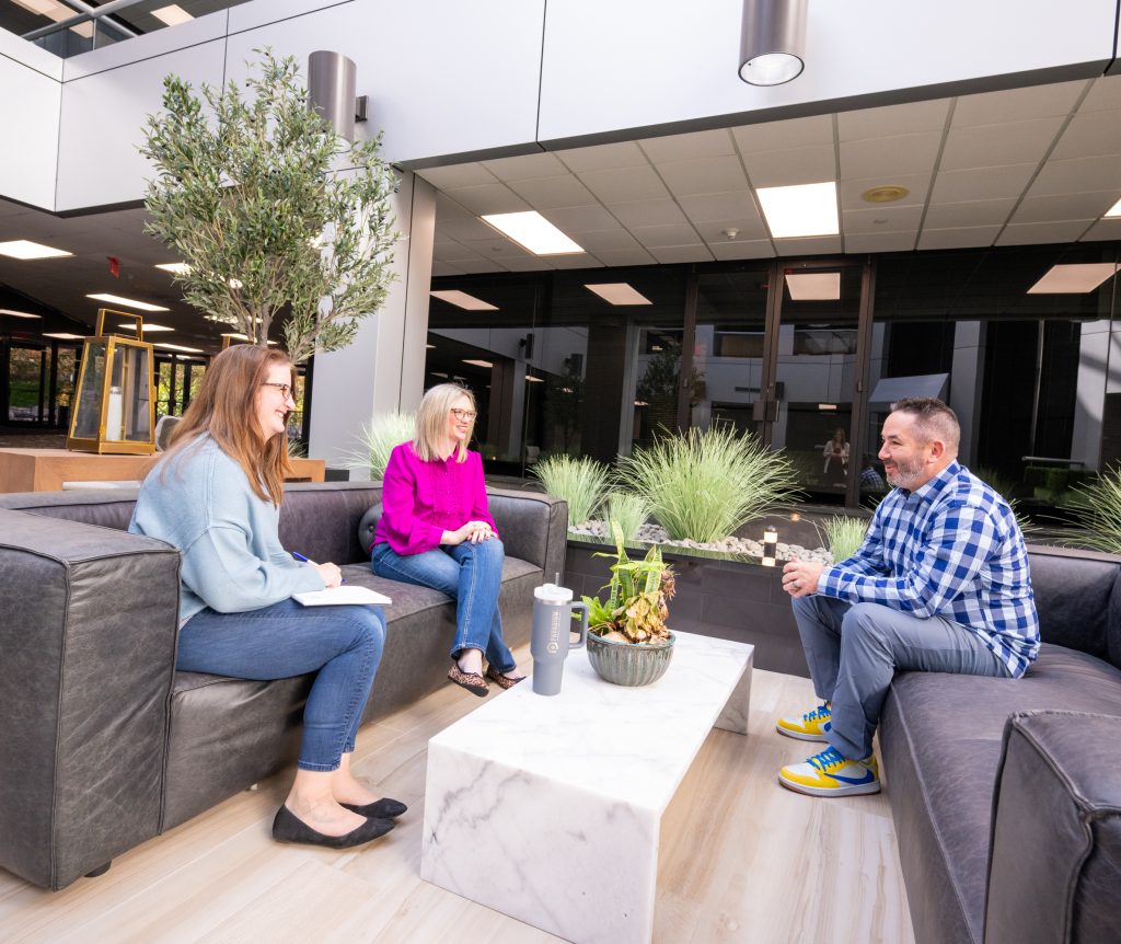 Paradigm Marketing and Design team having a discussion on marketing and web development services