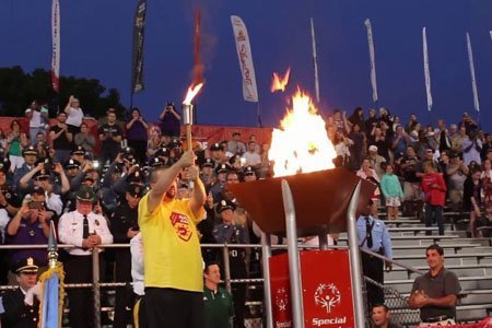 athlete lighting torch at Special Olympics ceremony