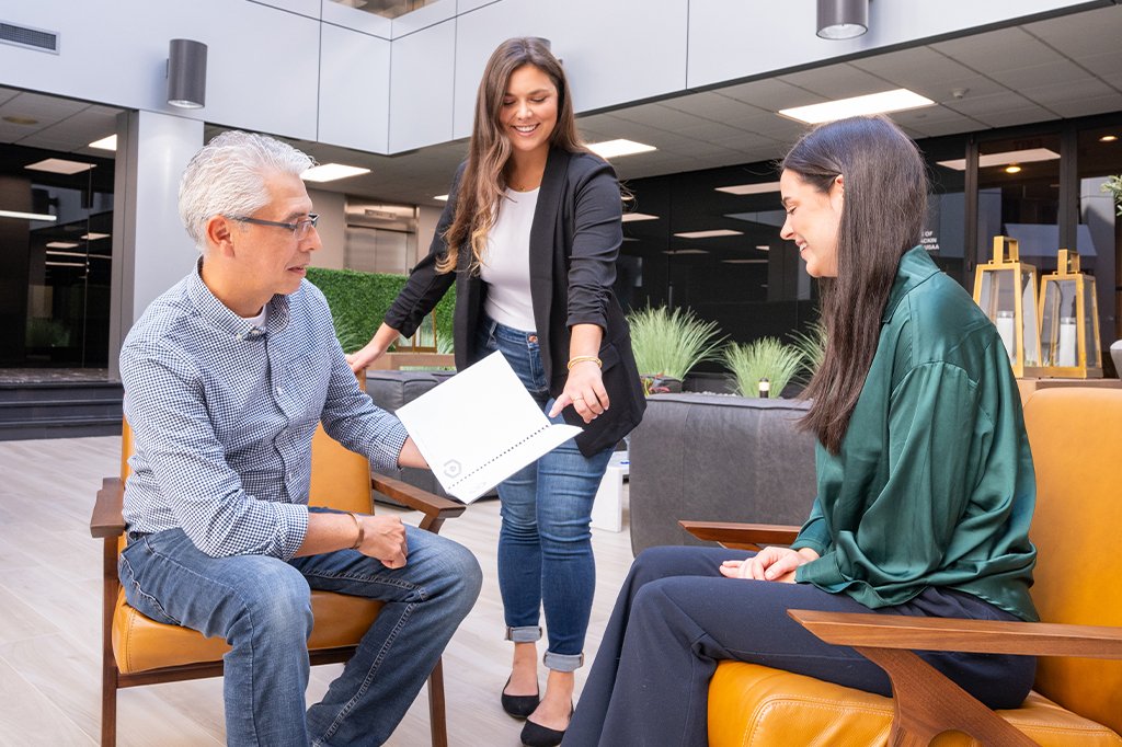 Three Paradigm Marketing and Design team members having a discussion